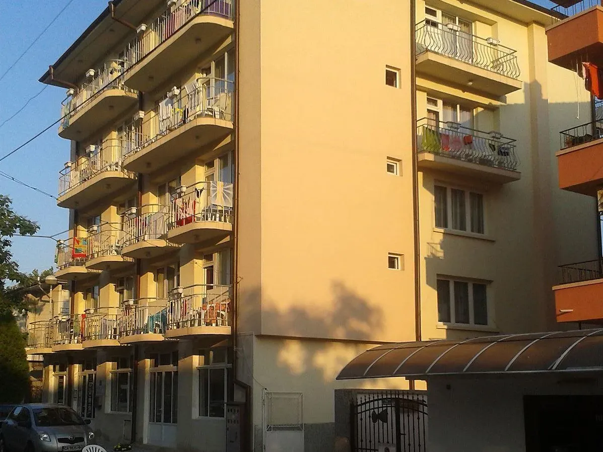 Vedere exterioară a unui hotel cu mai multe etaje, cu balcoane și steaguri colorate. - Vedere exterioară a unui hotel cu mai multe etaje, cu balcoane și steaguri colorate.