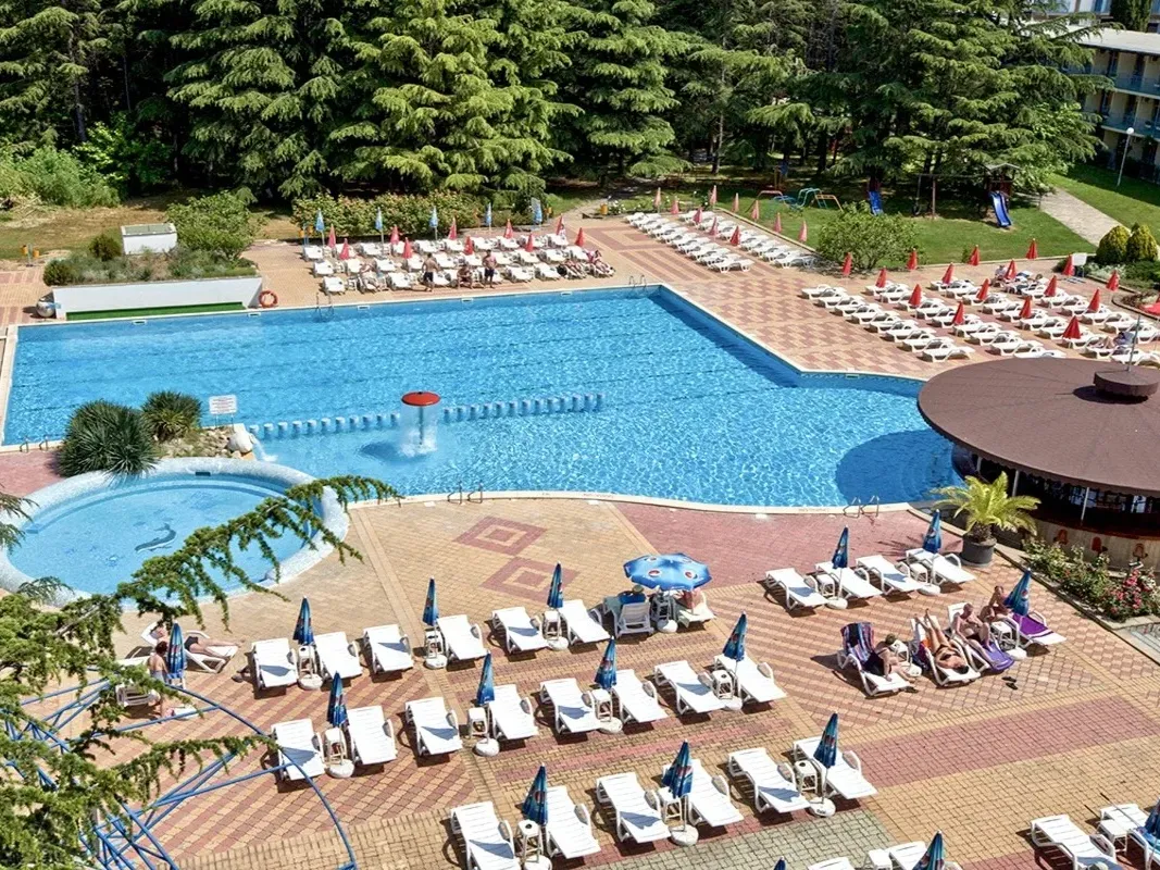 Clădirea hotelului cu o piscină care reflectă structura sub un cer albastru clar. - Clădirea hotelului cu o piscină care reflectă structura sub un cer albastru clar.