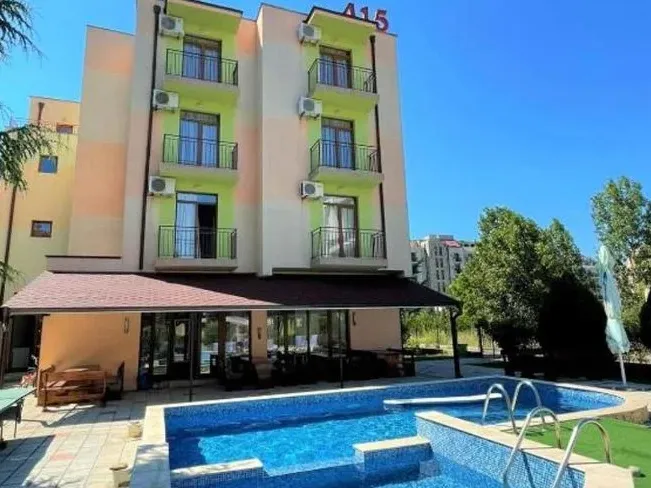 Vedere exterioară a unui hotel cu piscină și zonă de relaxare în aer liber. - Vedere exterioară a unui hotel cu piscină și zonă de relaxare în aer liber.